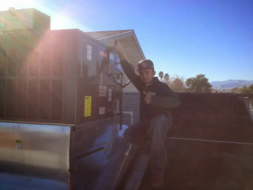 HVAC technician performing Air Duct Repair on a rooftop unit in Wahoo